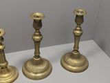 three gold candlesticks sitting on a white table