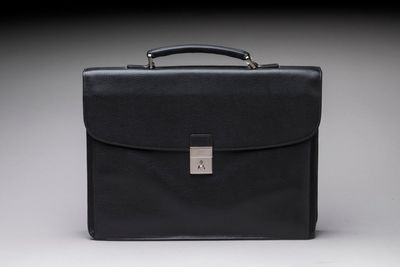 a black briefcase sitting on top of a white surface