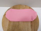 a pink object on a wooden plate on a table