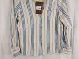 a white and blue striped shirt hanging on a white curtain