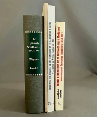 trois livres posés l'un à côté de l'autre sur une table