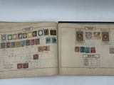 un livre ouvert avec des timbres, posé sur une table