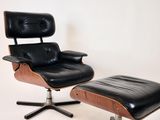 un fauteuil et un repose-pieds en cuir noir sur fond blanc
