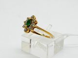 a close up of a gold ring with a green stone on it