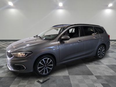 the grey car is parked in the garage on a checkered floor