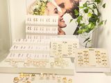 many rings on display on a table in front of a poster