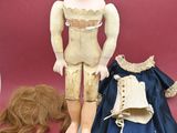 a doll that is standing next to a doll that is laying on the ground