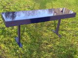 une table noire posée sur l'herbe, avec un miroir dessus