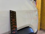 a measuring tape on the hood of a white car