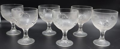 six verres à vin transparents posés sur une table noire