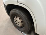a white truck with a flat tire parked on the side of the road