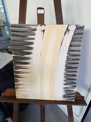 un chevalet sur lequel est posé un tableau, dans une pièce