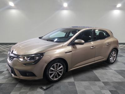 Une voiture beige est garée dans une pièce dont le sol est à carreaux.