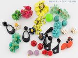 de nombreuses boucles d'oreilles de différentes couleurs sur un fond blanc