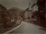 a black and white photo of a road with a church in the background