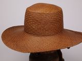 une photo d'un chapeau de paille marron posé sur une tête de mannequin