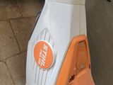 an orange and white blow mop sitting on the ground