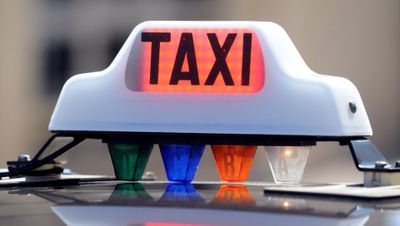 un panneau « taxi » placé sur le toit d'une voiture
