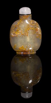 a glass bottle with a yellow and white design on it