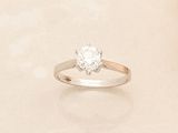 a ring with a diamond on it on a white surface