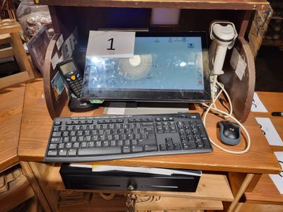 un ordinateur portable et un clavier posés sur un bureau, à côté d'un téléphone portable