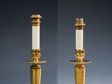 a pair of brass candles with white candlesticks on them