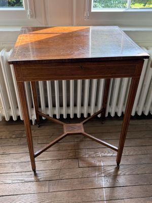 une petite table en bois avec un plateau en marbre, placée devant un radiateur