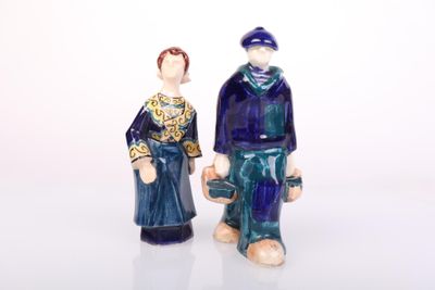 two figurines of a man and a woman standing next to each other