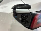 a close up of a car ' s rear end with an electric charger plugged into it