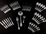 many forks and spoons arranged in a circle on a table