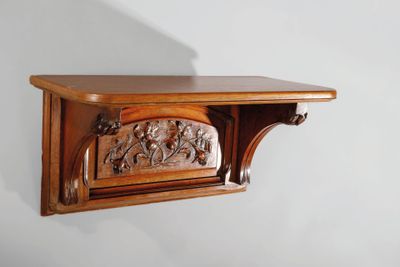 une étagère en bois ornée de sculptures, accrochée au mur