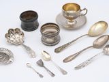 a lot of silver spoons and spoons on the table