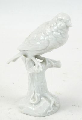 figurine en porcelaine représentant un oiseau perché sur une souche d'arbre