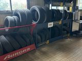 Les pneus sont empilés sur un rayonnage dans un garage doté de nombreuses fenêtres.