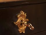 an antique black and gold desk with a drawer on top of it