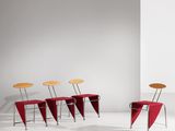 trois chaises et une table dans une pièce blanche aux murs blancs