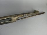 a gun that is on the wall next to a cup
