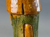 a close up of a vase with a bird on top of it