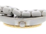 a close up of a watch with a white dial and a gold band