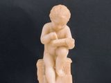 a statue of a boy sitting on top of a box