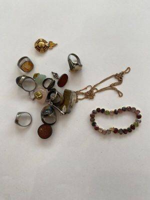 many different pieces of jewelry on a white surface
