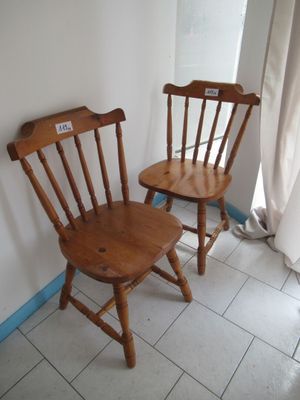 deux chaises en bois assises l'une à côté de l'autre sur un sol carrelé
