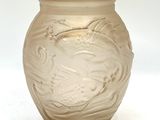 un vase en verre orné d'un oiseau, posé sur une table
