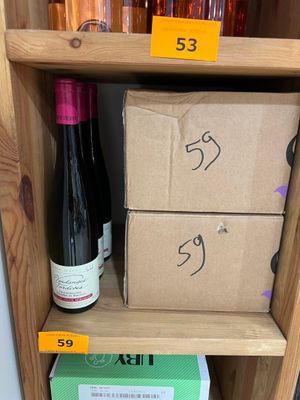 des bouteilles de vin sur une étagère dans un magasin, avec leurs étiquettes de prix