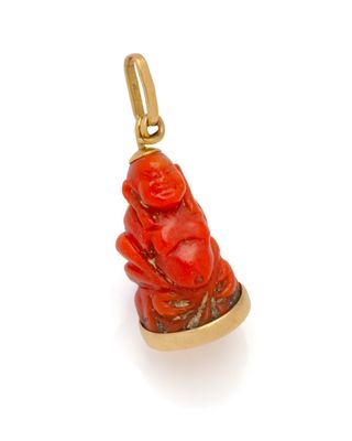 a close up of a red buddha charm on a white background