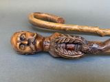 a wooden stick with a head on it and a cane in the shape of a man