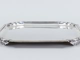 a silver tray with a handle on a white surface