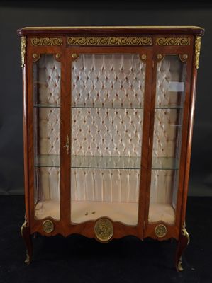 an antique display cabinet with glass doors and gold trimmings