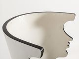 a white vase with a face cut out of it