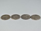 three quarters of the same type of coin are shown on a white surface